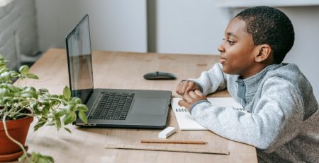 a young boy uses a laptop