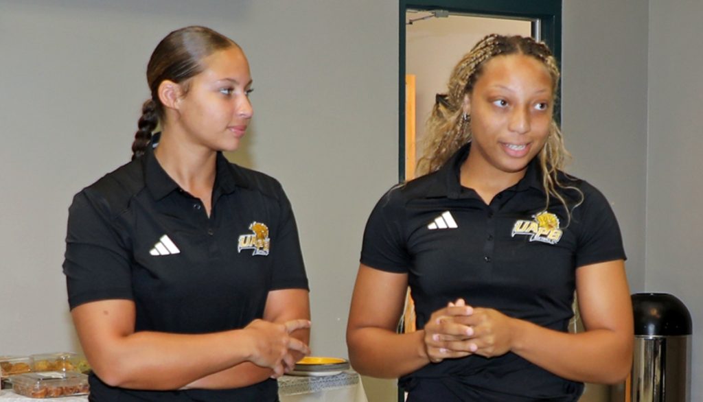 two UAPB athletes speaking at a meeting