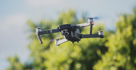 a drone flying on a blurred green and blue background