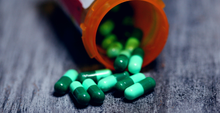 closeup photo of pills falling out of a prescription bottle