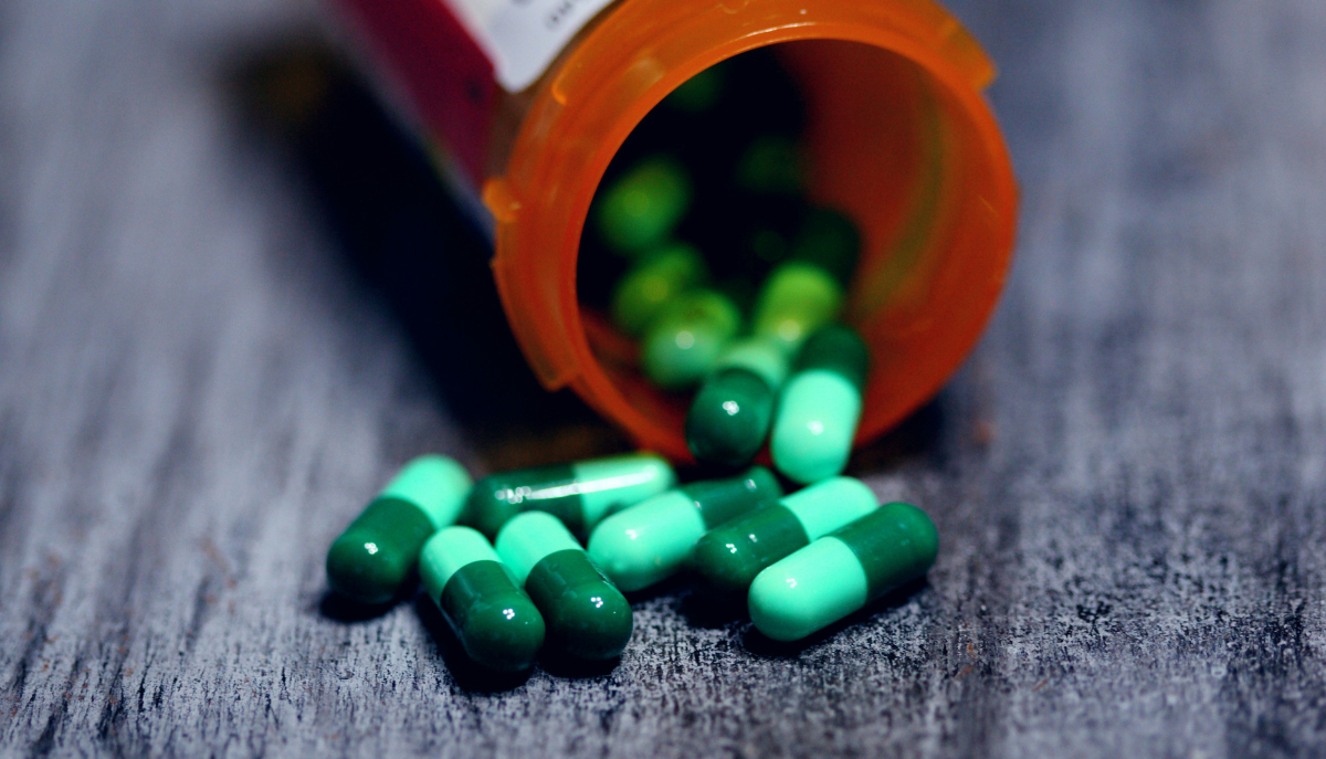 closeup photo of pills falling out of a prescription bottle