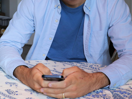 a person's torso and hands, holding a cellphone