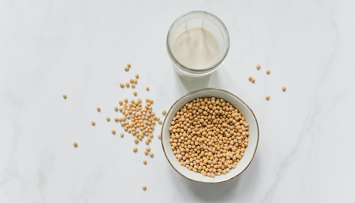 a cup of soy milk and bowl of soybeans