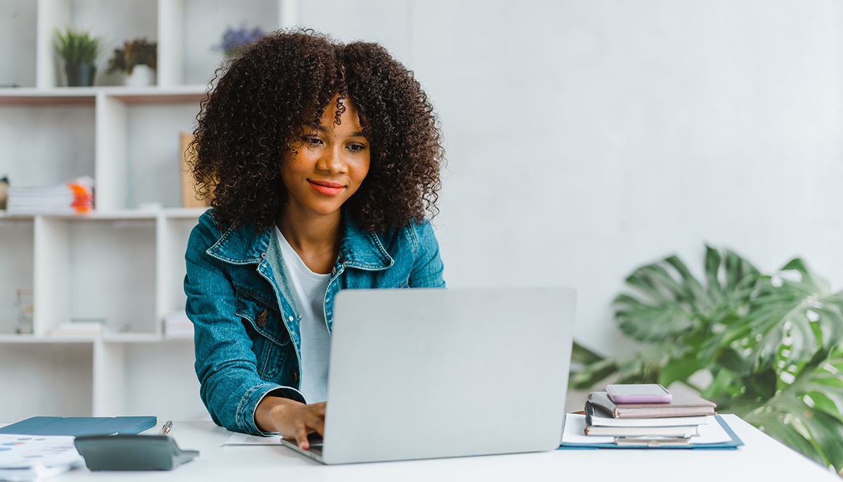 a woman looking at a laptop in her home