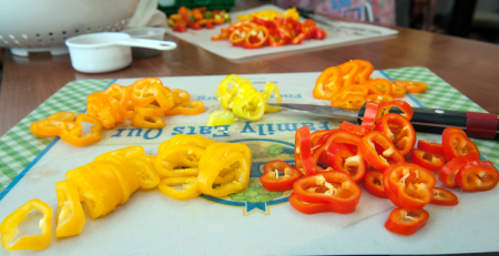 peppers being sliced on a cutting board