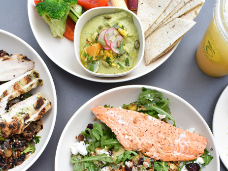 photo of plates of healthy foods, including pita, veggies, salmon, chicken, and avocado toast