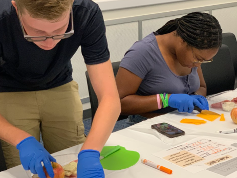 two teens prepare food for a charcuterie board