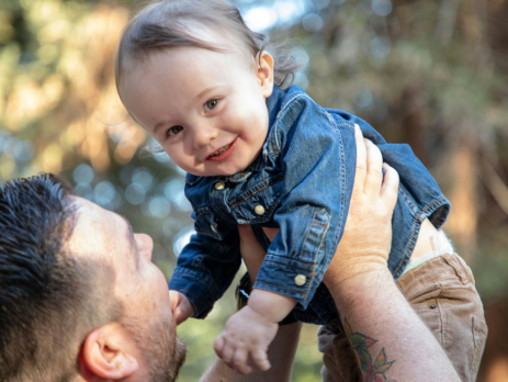 a father raises his child in the air