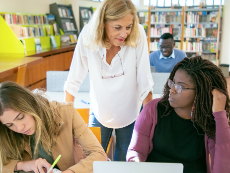 a professor talks to two women students