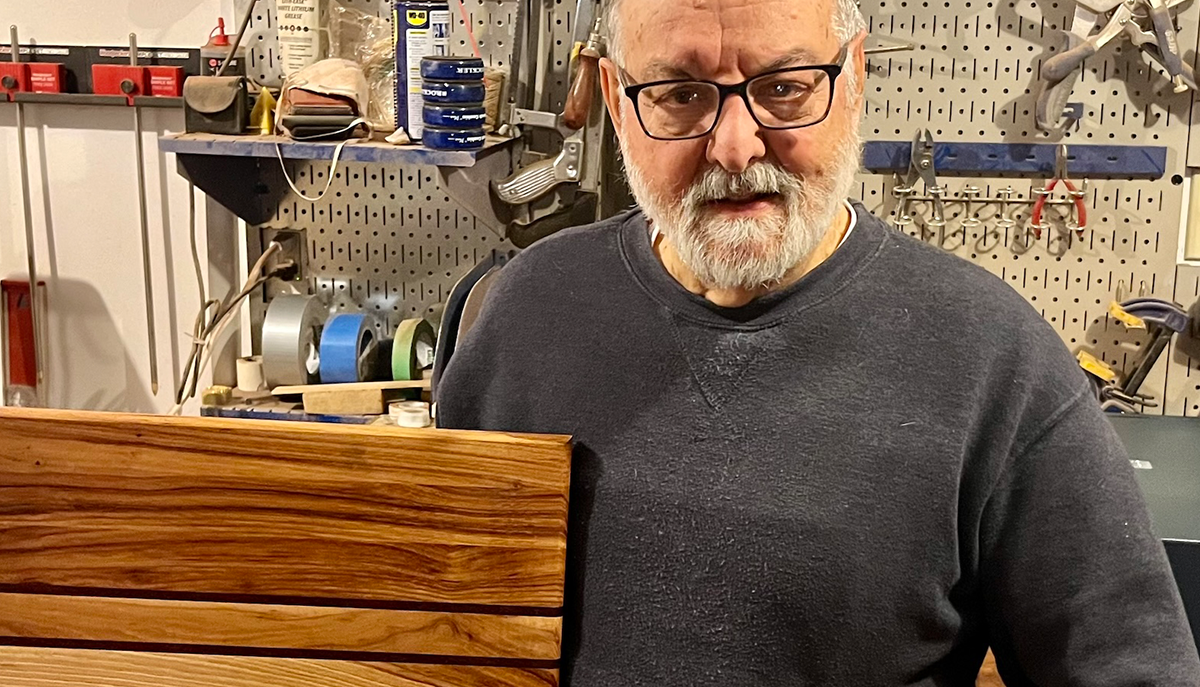 a man holding a wood pallet in a workshop