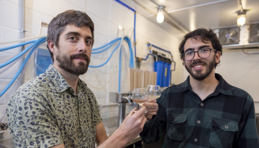 Scott Lafontaine stands with Bernardo Guimaraes in their small-scale beverage development facility