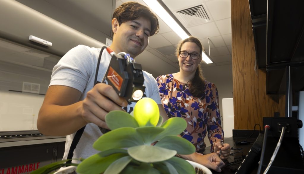 Mario Soto and Aurelie Poncet with a plant and a light-emitting device.