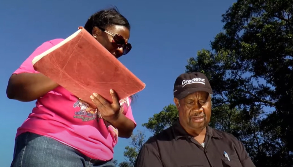 two people reference a tablet in an outdoor setting