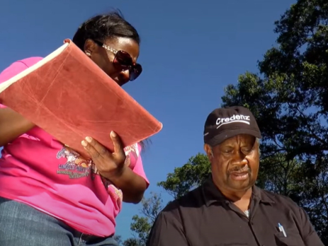 two people reference a tablet in an outdoor setting