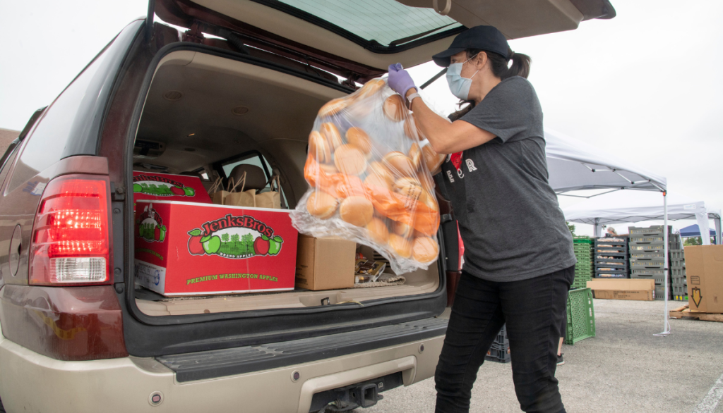 a person loading food into a car trunk