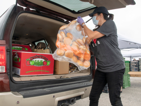 a person loading food into a car trunk