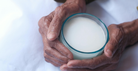 hands holding a glass of milk