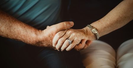 closeup of two seniors holding hands