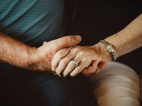 closeup of two seniors holding hands