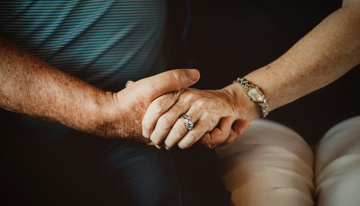 closeup of two seniors holding hands