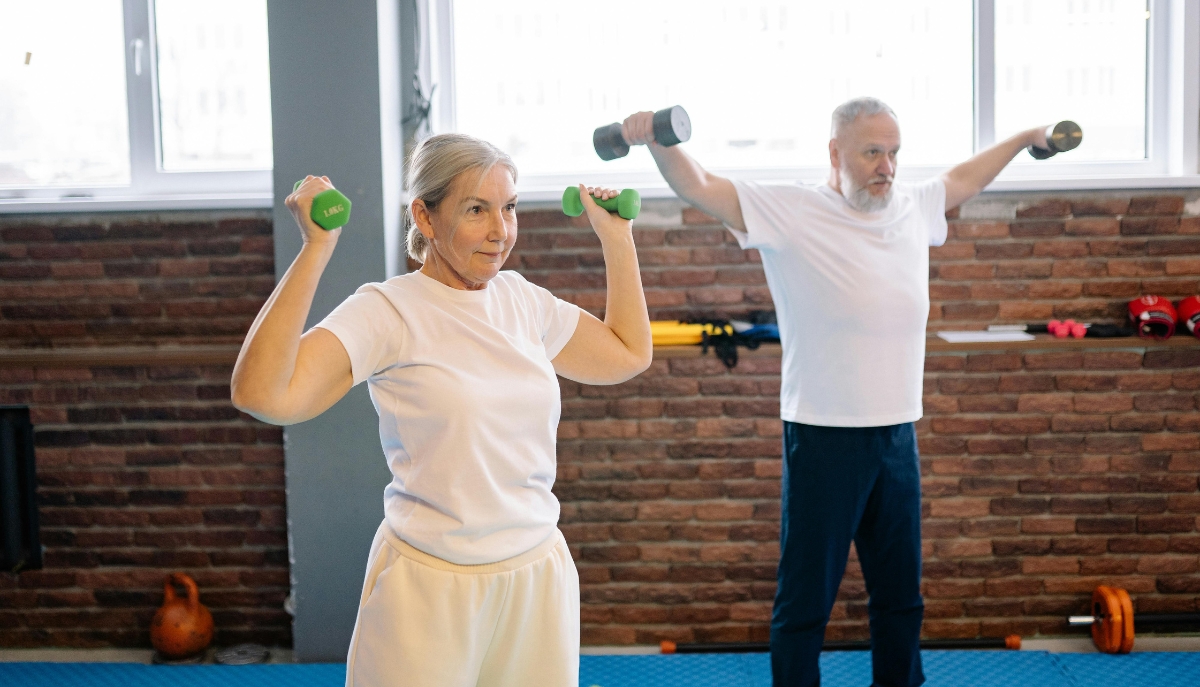two seniors lifting small dumbbells