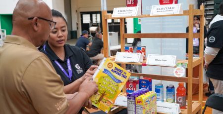 an Extension agent shows a member of the public how to read a nutrition label on a box of cereal