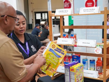 an Extension agent shows a member of the public how to read a nutrition label on a box of cereal