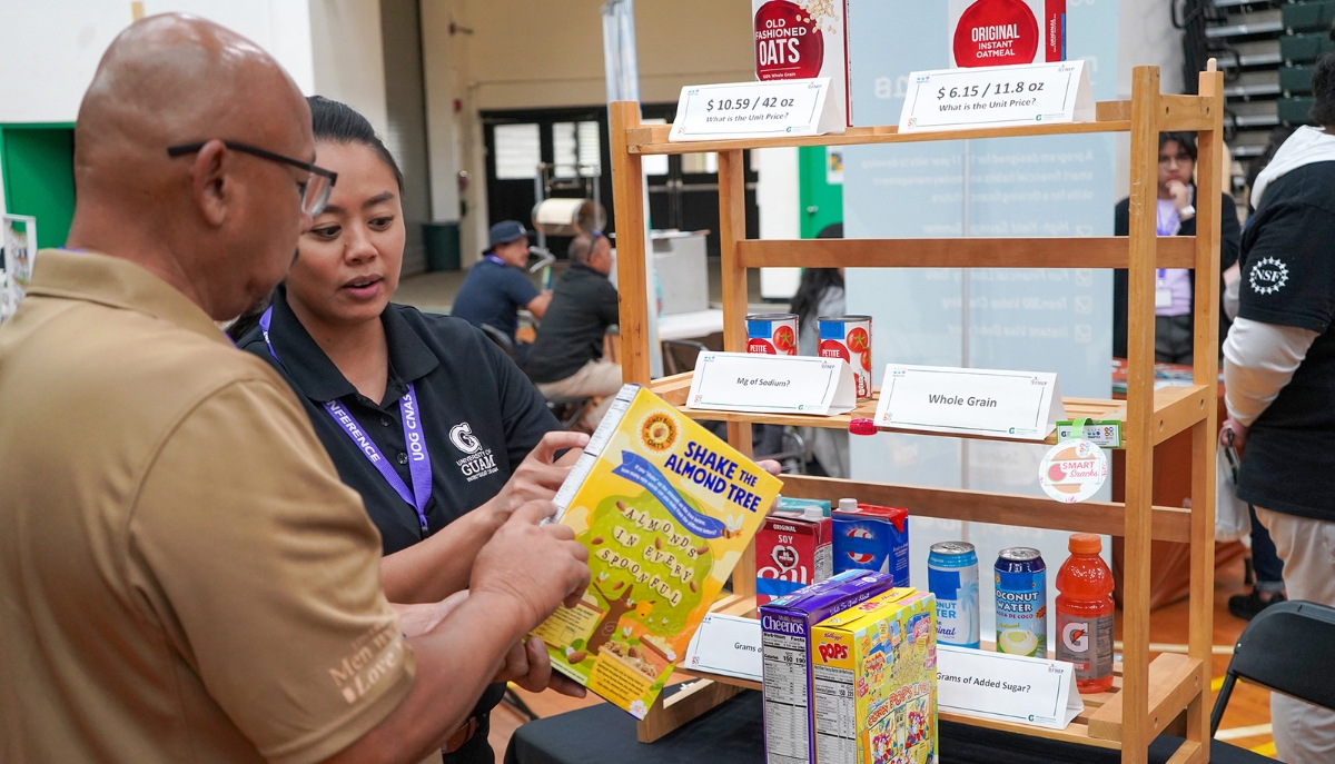 an Extension agent shows a member of the public how to read a nutrition label on a box of cereal