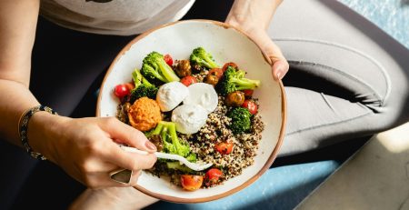 a young person wearing exercise clothing eating a healthy meal