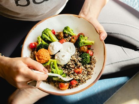 a young person wearing exercise clothing eating a healthy meal
