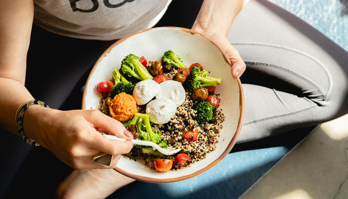 a young person wearing exercise clothing eating a healthy meal