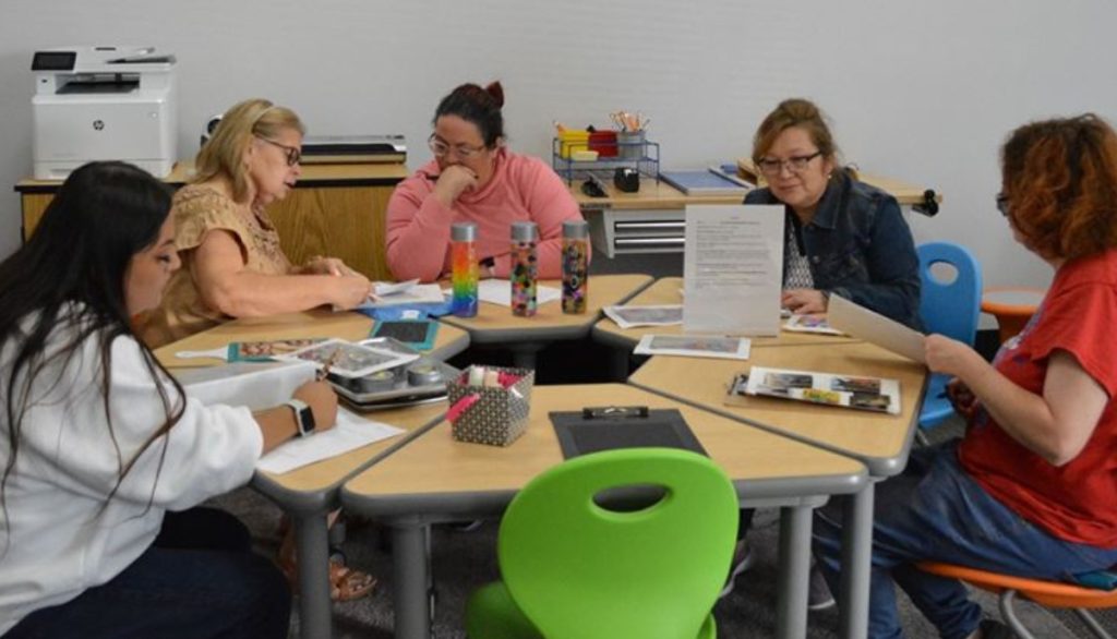 Individuals sitting around a table in a room.
