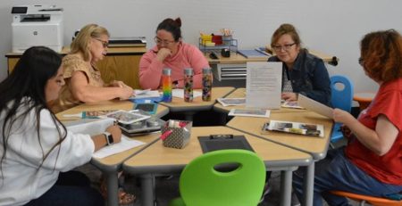 Individuals sitting around a table in a room.