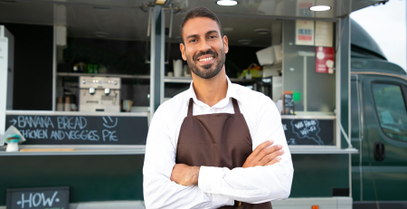 smiling person in front of a food truck