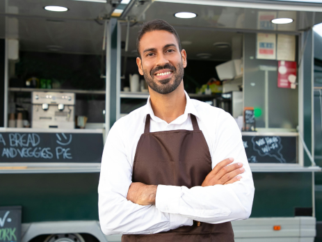 smiling person in front of a food truck