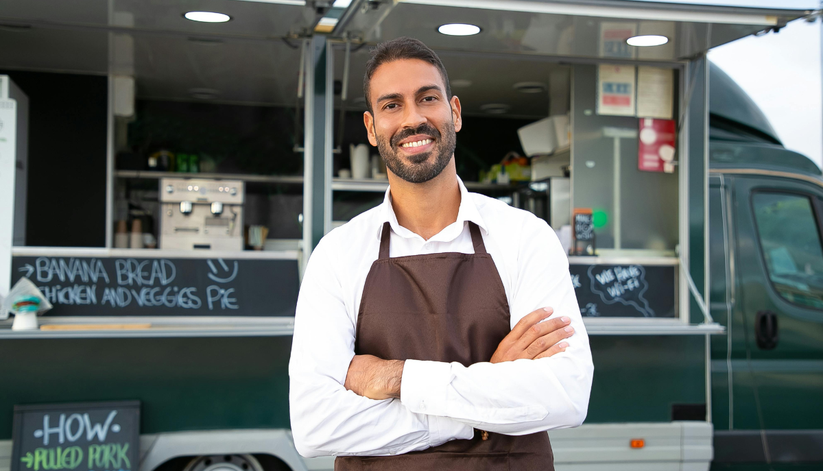 smiling person in front of a food truck