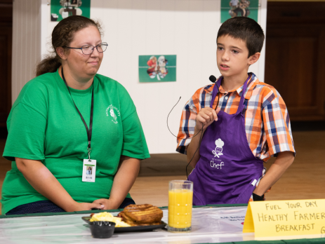 a 4-h participant and leader present a cooked meal