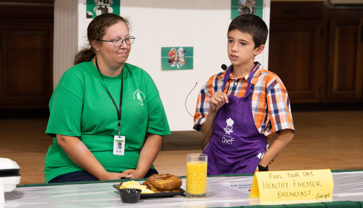 a 4-h participant and leader present a cooked meal