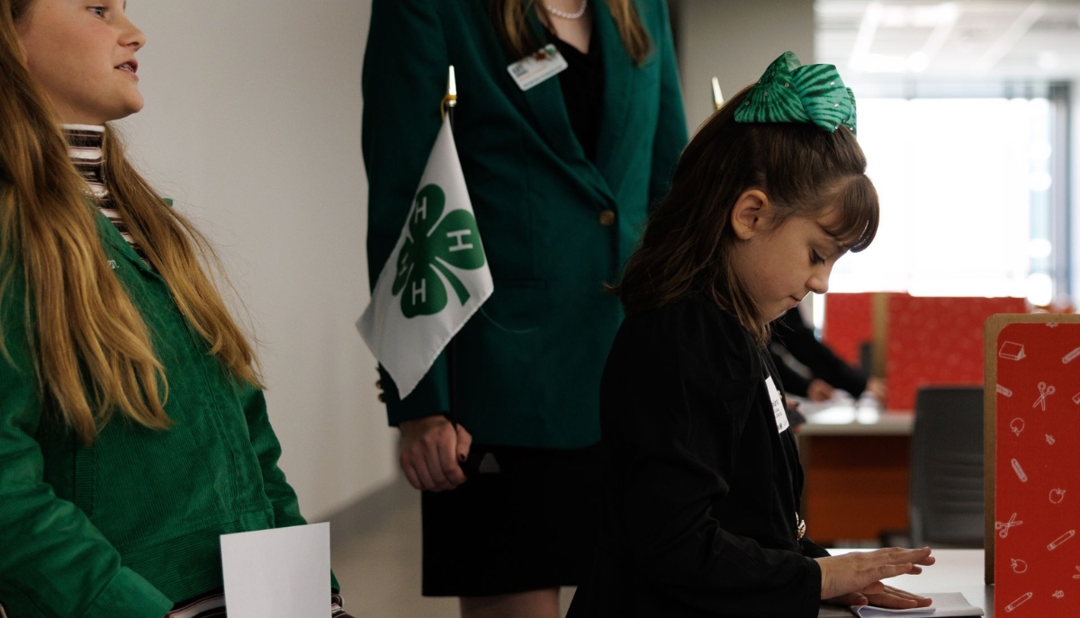 a 4-H member participates in a mock voting exercise