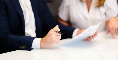 two people in business attire look at a document