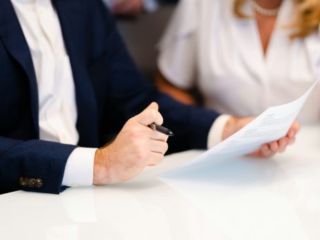 two people in business attire look at a document