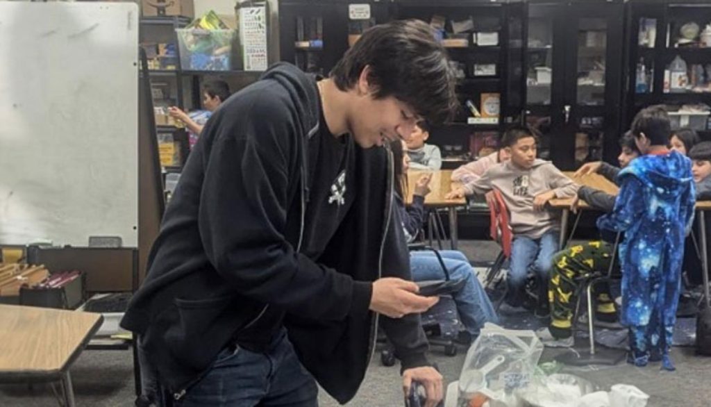One of the participants in the Training for Teens program prepares a science experiment for his after-school class.