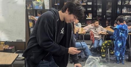 One of the participants in the Training for Teens program prepares a science experiment for his after-school class.