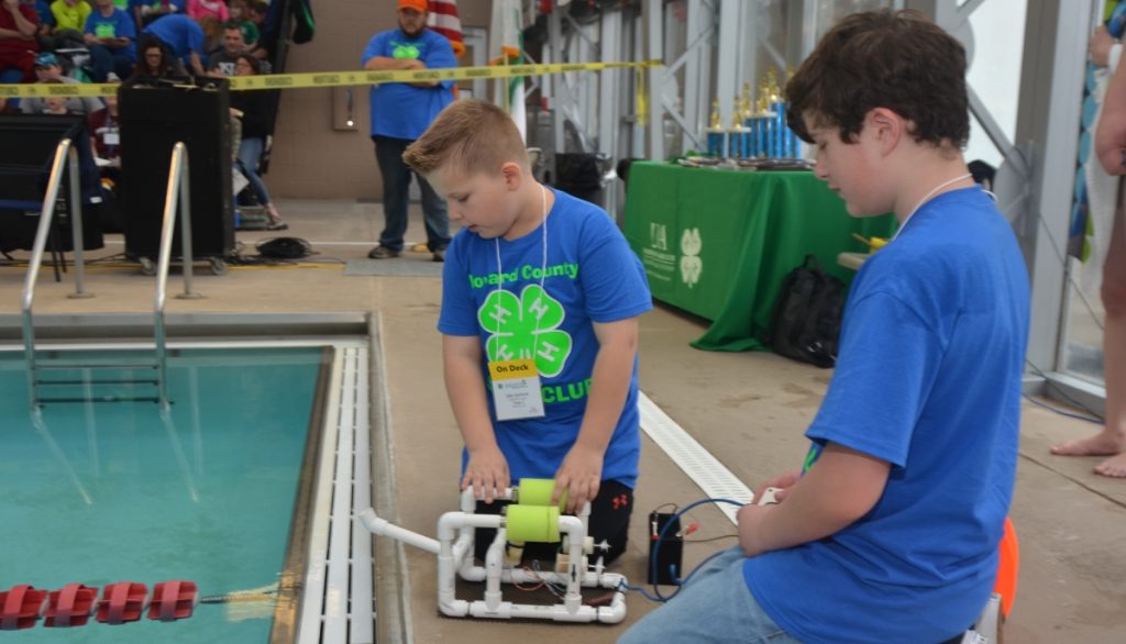 two 4-Hers with their machine at the side of a pool