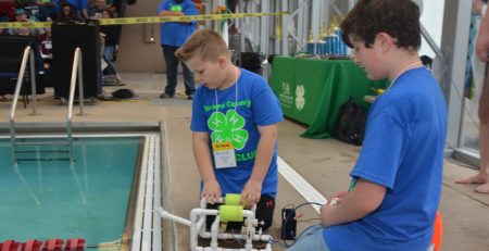 two 4-Hers with their machine at the side of a pool