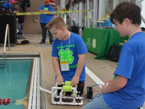 two 4-Hers with their machine at the side of a pool