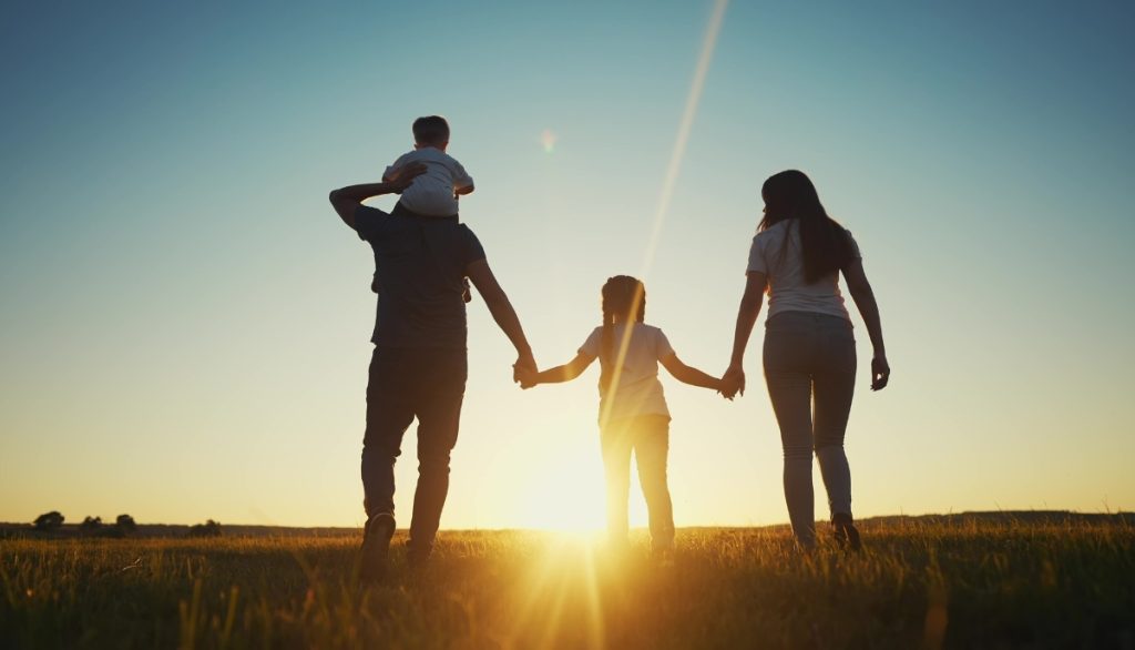 a family in silhouette, holding hands