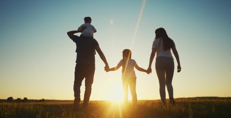 a family in silhouette, holding hands