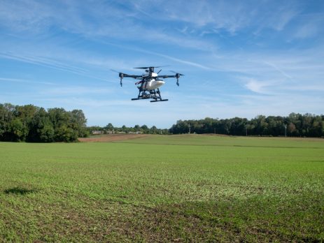 A drone flies over a field.